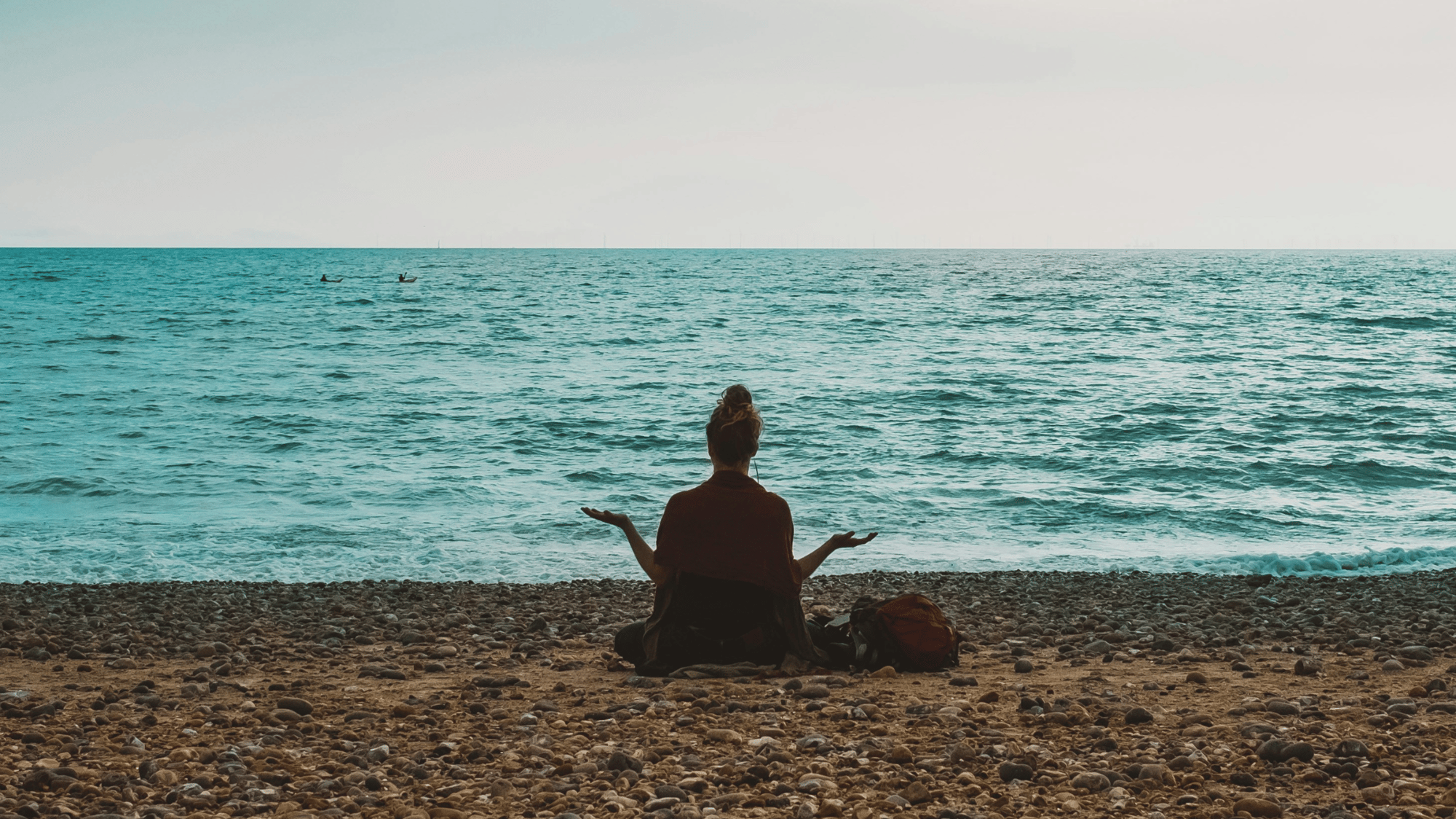 Yogi sitting on beach in early morning light