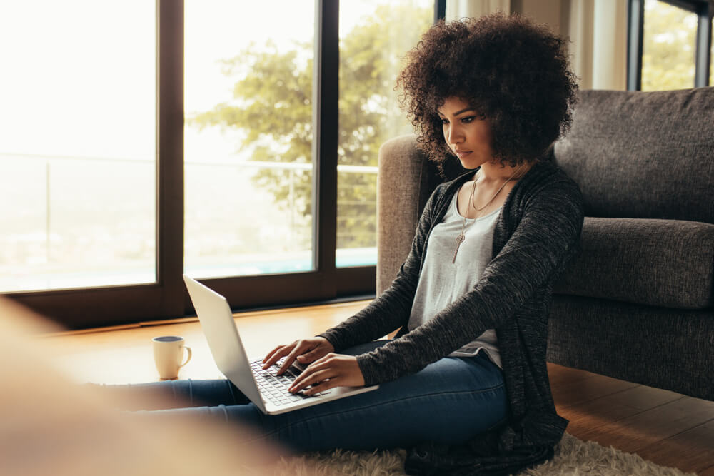 black woman sitting on floor with her computer